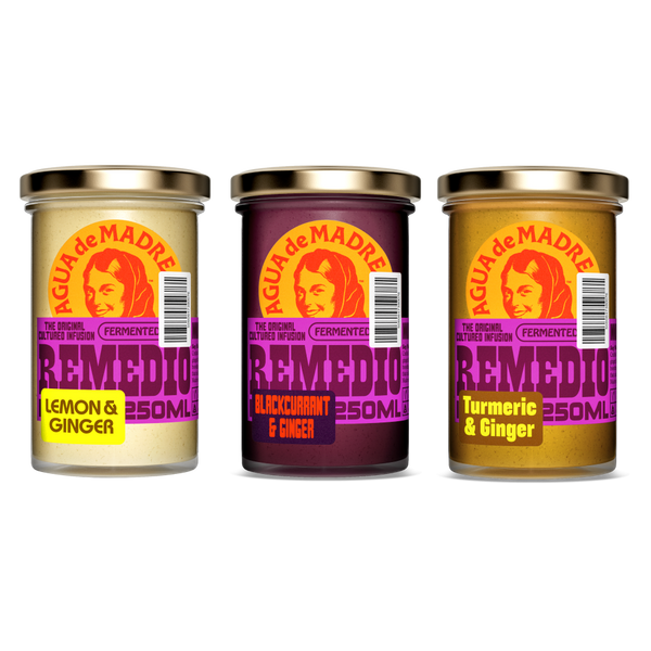 Three jars of Aguá de Madre Remedio with colorful labels on a white background